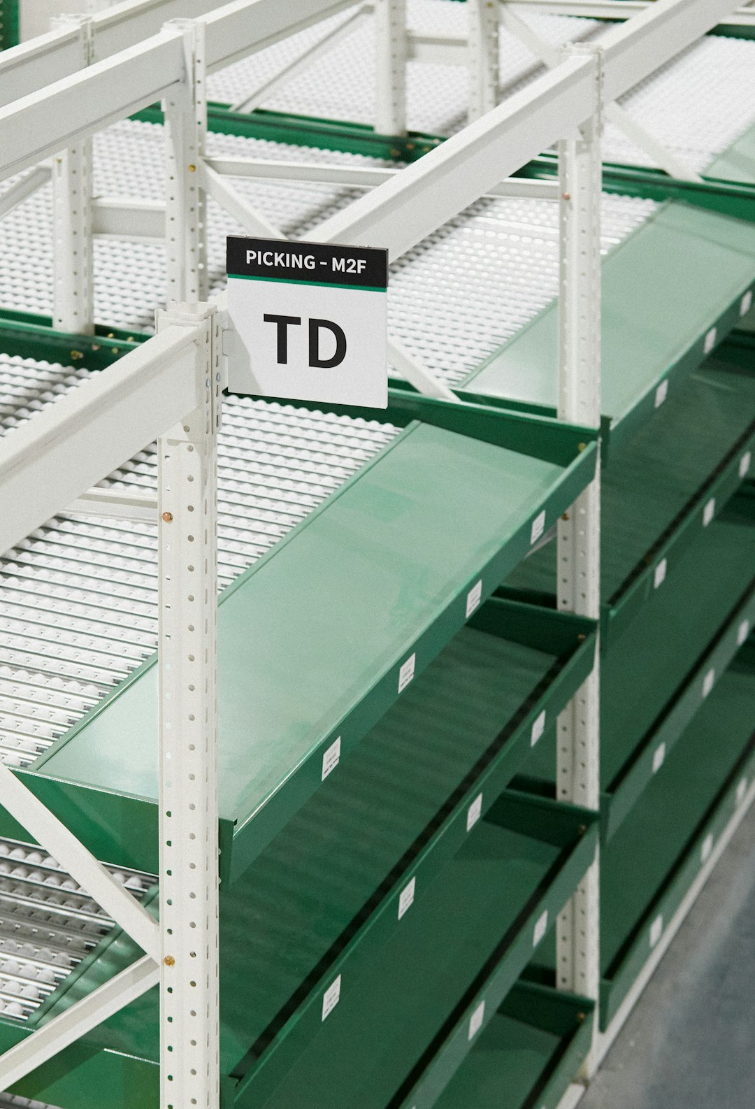empty-green-shelves-in-a-warehouse-with-signs-l3tpd02-thk